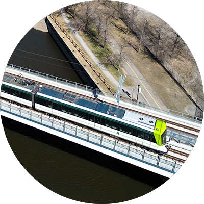 Overhead photo of two REM cars crossing a bridge