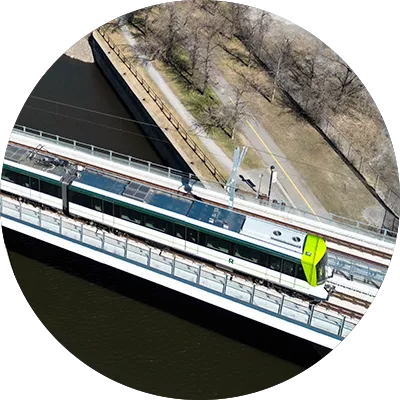 Overhead photo of two REM cars crossing a bridge